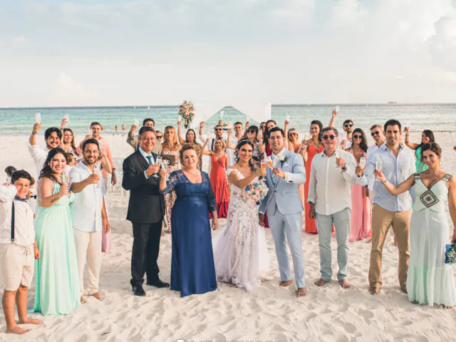 Casal e convidados celebrando o casamento durante o verão em Destination Wedding ao pôr do sol