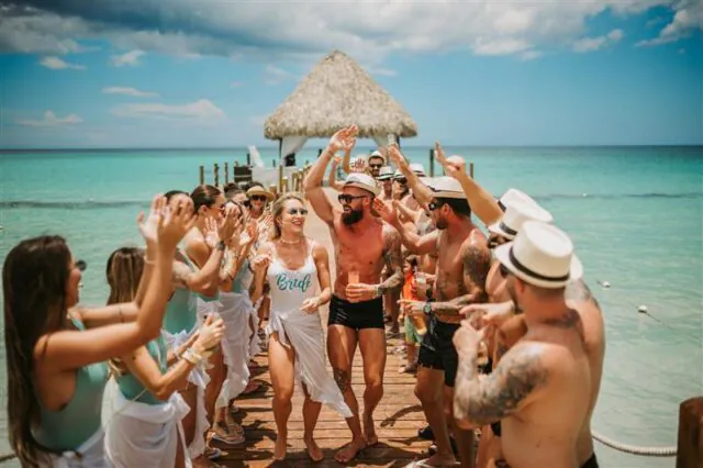 Noiva e convidados celebrando em píer durante casamento na praia em destination wedding.
