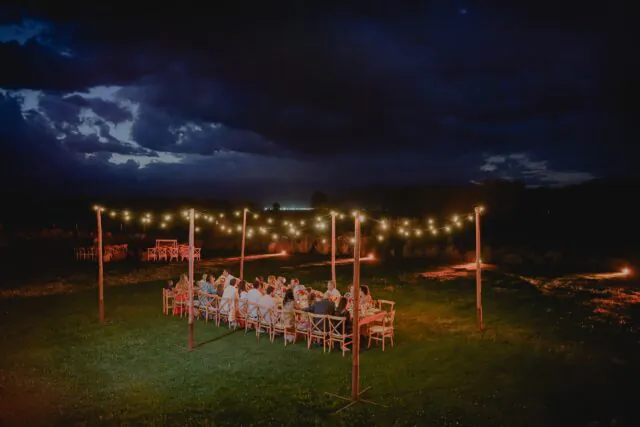 Jantar de casamento ao ar livre com iluminação decorativa em destination wedding.