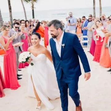 Marcella e Ingo saindo da cerimônia na praia entre os convidados
