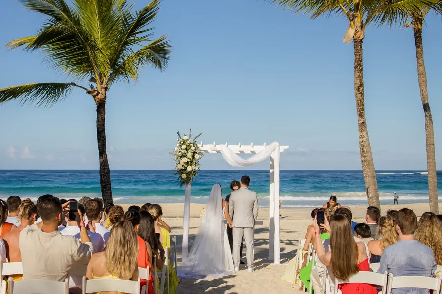 Cerimônia na praia do Caribe, com o casal no altar de frente para o mar e os convidados sentados